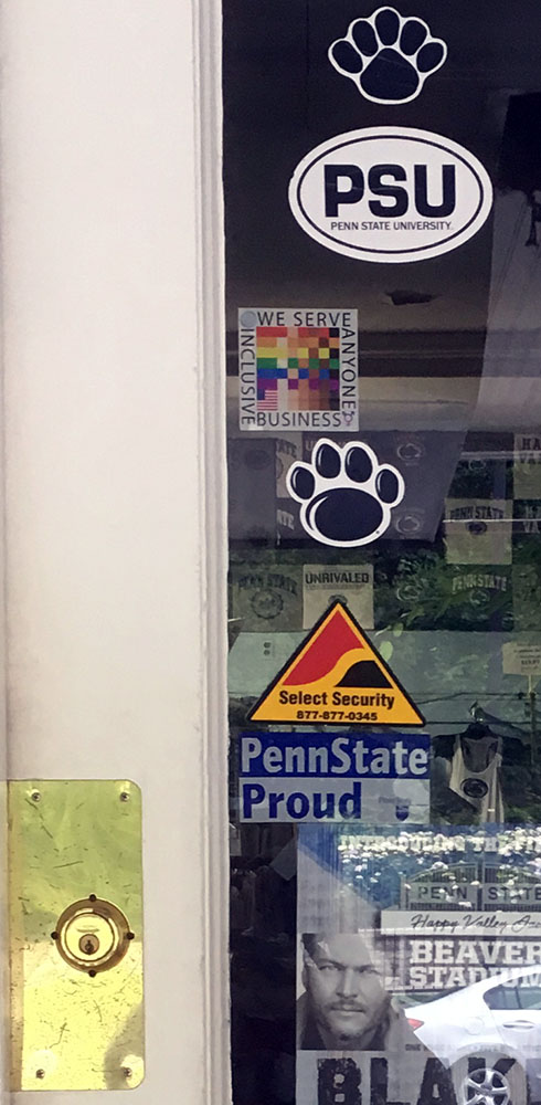 The 100% sign is seen in and entry door beside two Penn State Logo's